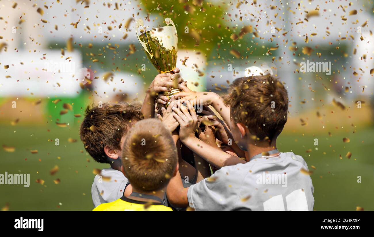 Happy Football Team Rising Golden Trophy on Confetti Celebration Moment. Happy Kids Winning Soccer Touranment for School Sports Teams Stock Photo