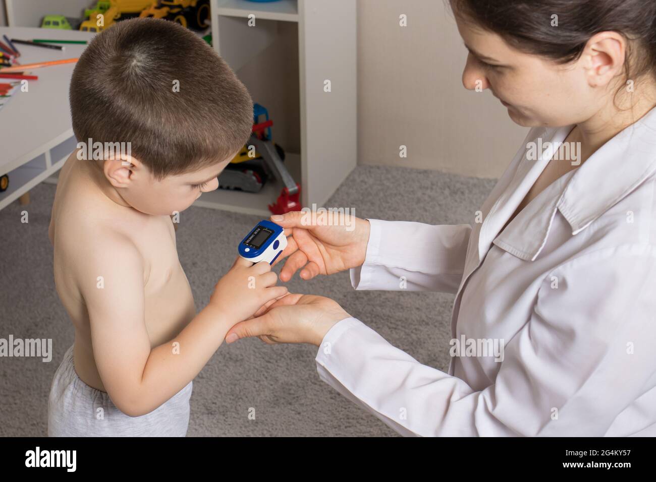 The pediatrician measures the child's blood oxygen level with a pulse