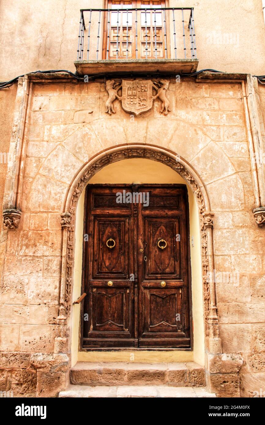 Old stone facade made of carved stone and vintage wooden door in a ...