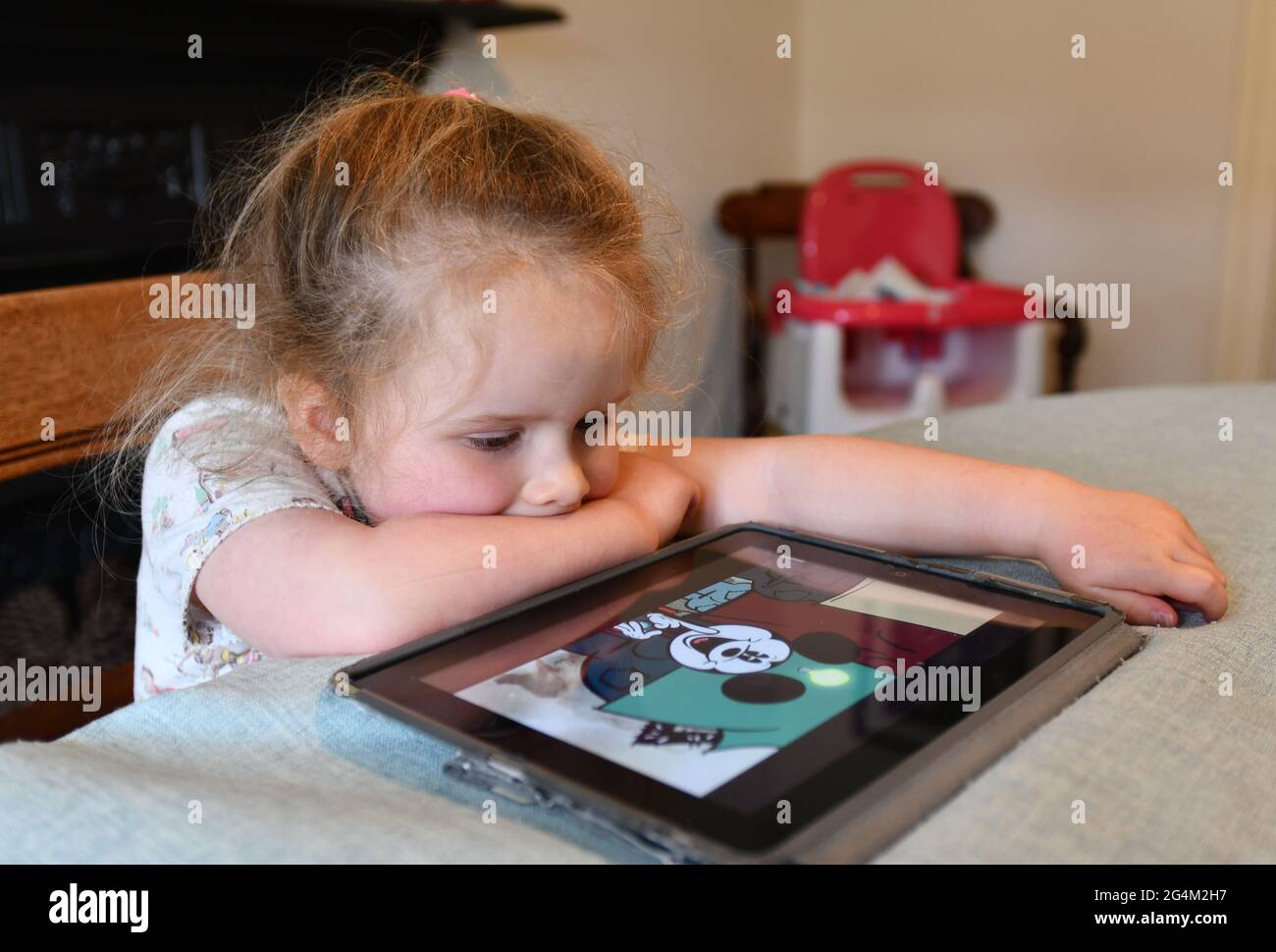 Child girl watching video on Apple iPad tablet at home