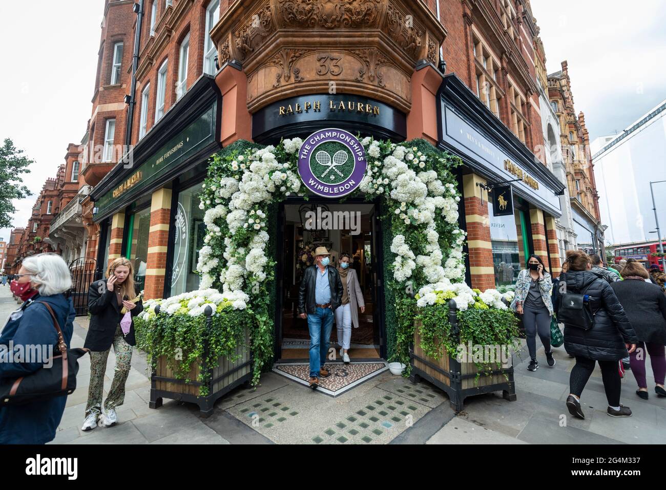 London, UK.  22 June 2021.  People pass the exterior of the Ralph Lauren store in Sloane Square, decorated ahead of this year’s upcoming Wimbledon tennis championships at the All England club. Ralph Lauren supplies outfits for officials at the event.  Lockdown restrictions will limit crowds, but the finals will be at full capacity when restrictions are relaxed.  Credit: Stephen Chung / Alamy Live News Stock Photo