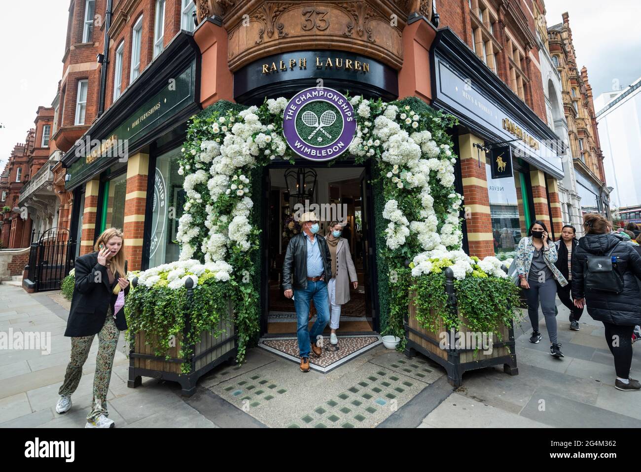 London, UK.  22 June 2021.  People pass the exterior of the Ralph Lauren store in Sloane Square, decorated ahead of this year’s upcoming Wimbledon tennis championships at the All England club. Ralph Lauren supplies outfits for officials at the event.  Lockdown restrictions will limit crowds, but the finals will be at full capacity when restrictions are relaxed.  Credit: Stephen Chung / Alamy Live News Stock Photo