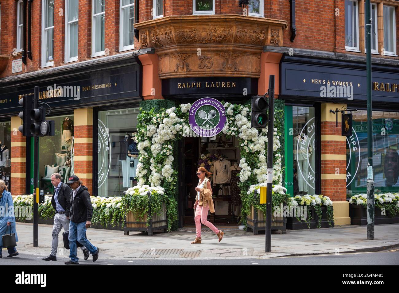 London, UK.  22 June 2021.  People walk past the exterior of the Ralph Lauren store in Sloane Square, decorated ahead of this year’s upcoming Wimbledon tennis championships at the All England club. Ralph Lauren supplies outfits for officials at the event.  Lockdown restrictions will limit crowds, but the finals will be at full capacity when restrictions are relaxed.  Credit: Stephen Chung / Alamy Live News Stock Photo