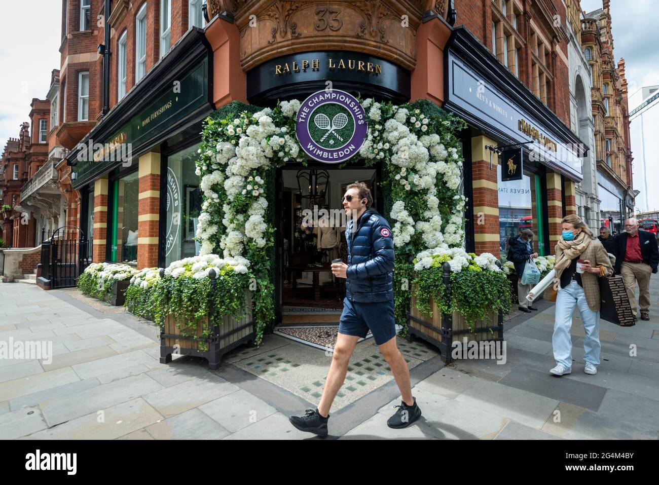 London, UK.  22 June 2021.  People walk past the exterior of the Ralph Lauren store in Sloane Square, decorated ahead of this year’s upcoming Wimbledon tennis championships at the All England club. Ralph Lauren supplies outfits for officials at the event.  Lockdown restrictions will limit crowds, but the finals will be at full capacity when restrictions are relaxed.  Credit: Stephen Chung / Alamy Live News Stock Photo