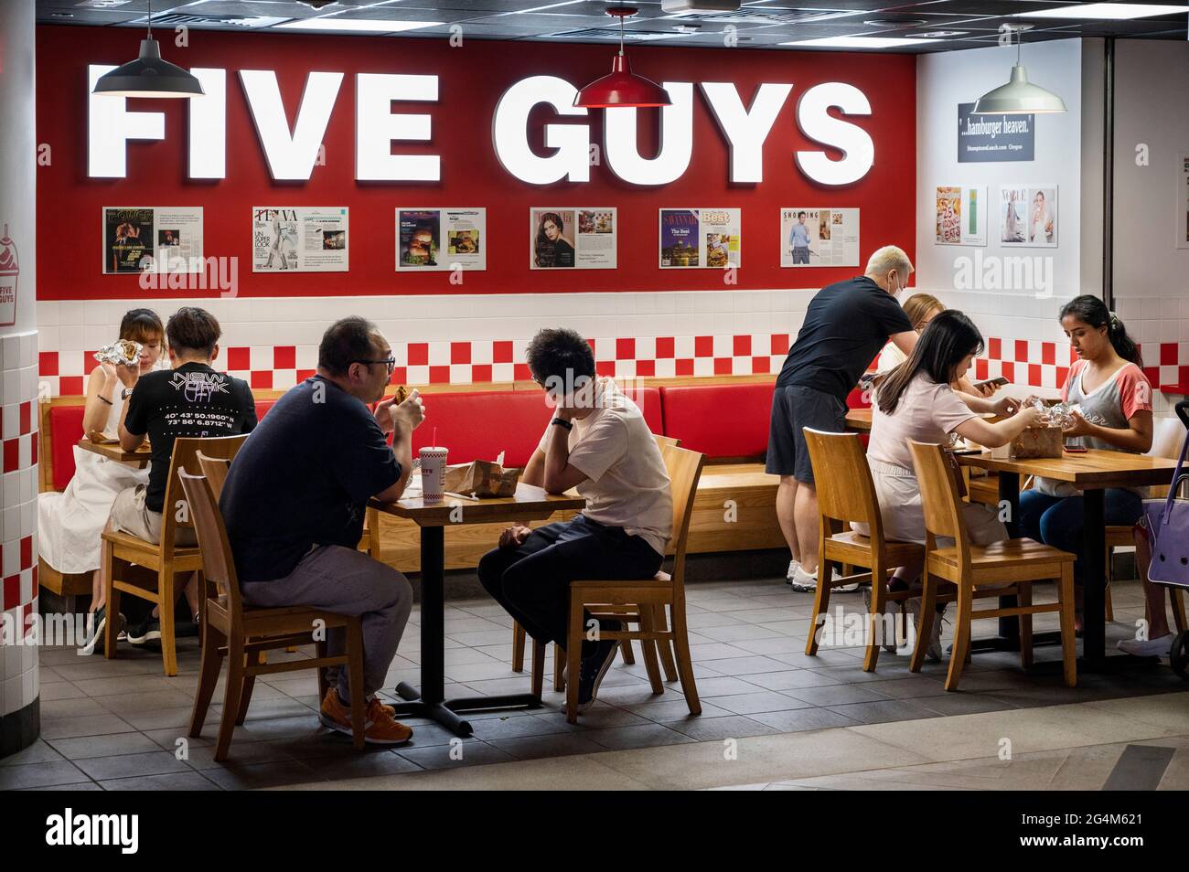 Customers eat at the American fast casual restaurant chain Five Guys in