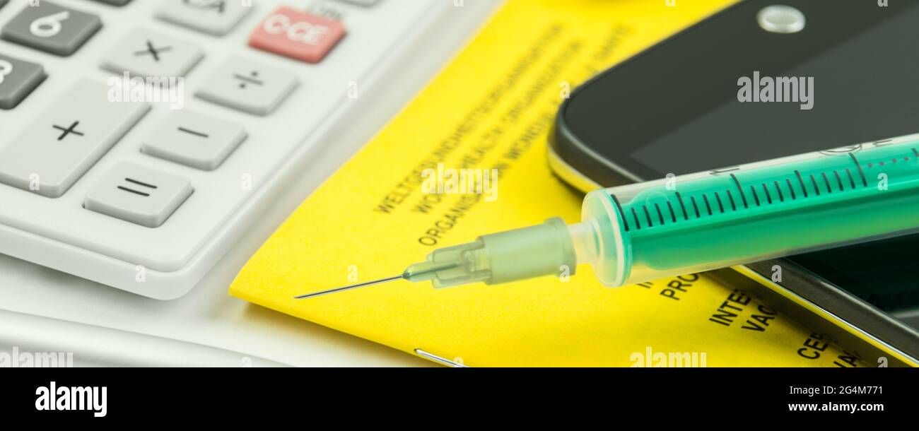 Impfpass und Handy mit Rechner Stock Photo