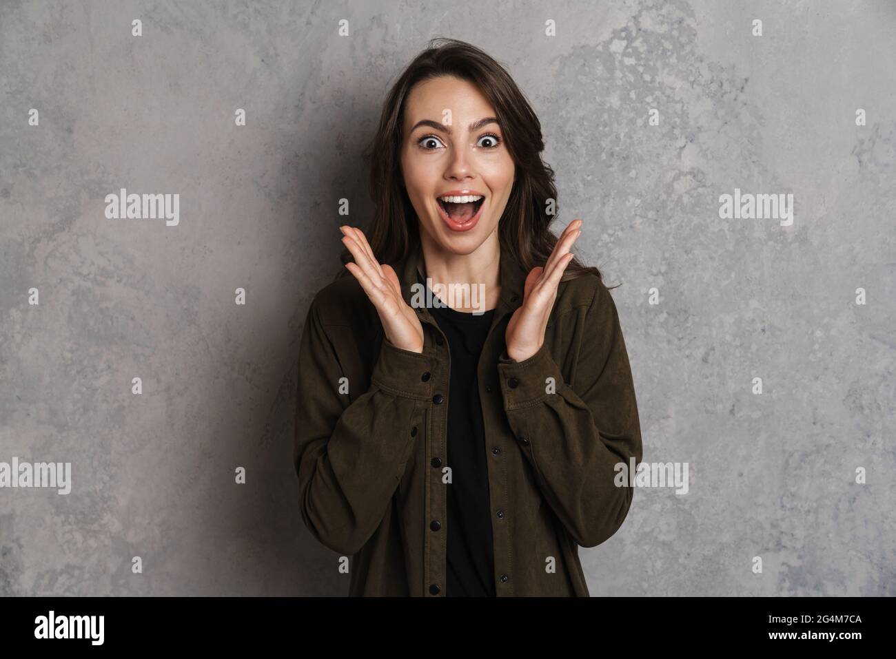 Excited beautiful brunette girl expressing surprise at camera isolated ...