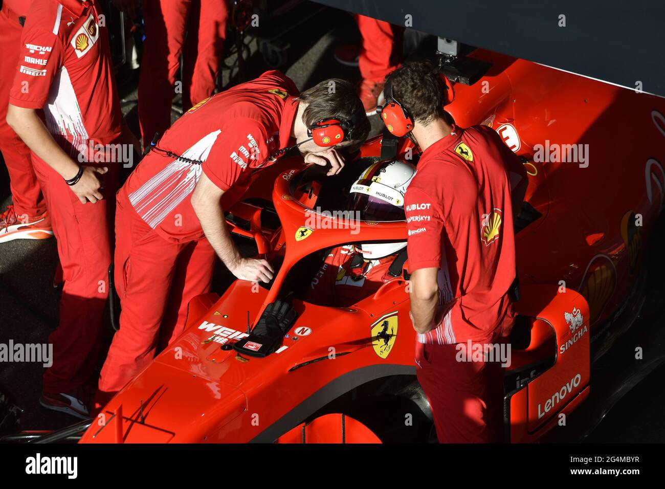 Ferrari's pit stop crew working around the Ferrari Formula One at the ...