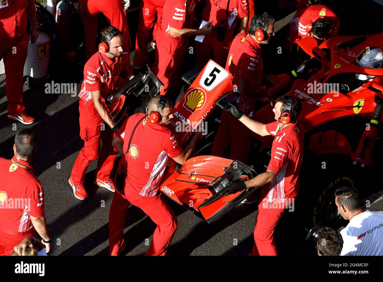 Ferrari's pit stop crew working around the Ferrari Formula One at the ...