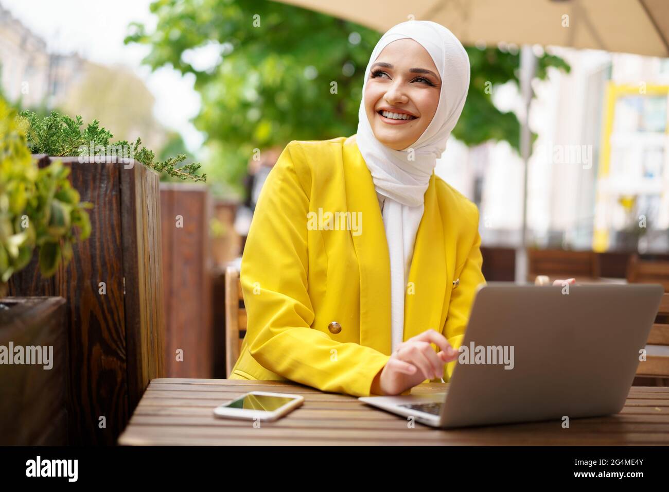 Beautiful smiling muslim woman with laptop at cafe Stock Photo - Alamy