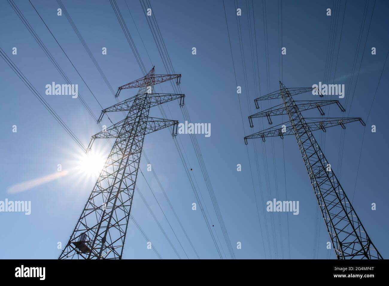 Power pylons and the sun Stock Photo