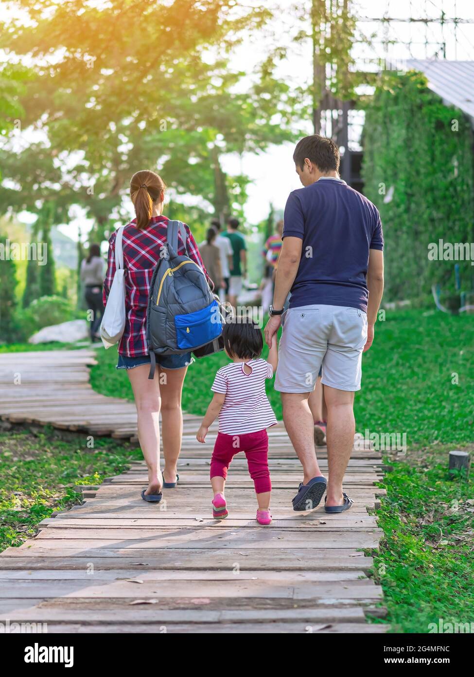 Back view of Asian Father hand holding lovely daughter walking on ...