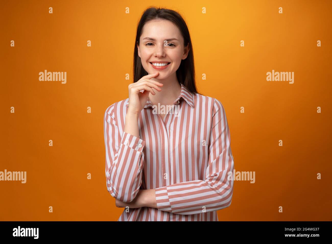 Studio portrait of beautiful young woman thinking against yellow ...