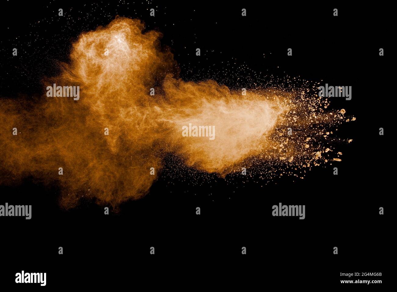 Freeze motion of brown dust explosion.Stopping the movement of brown powder.Explosive brown powder on black background. Stock Photo