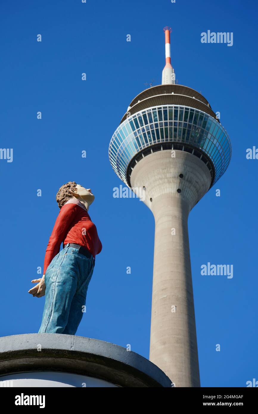 Selective focus on 'Marlis', a life-size sculpture by the artist Christoph Pöggeler. She seems to be looking at Düsseldorf's landmark, the Rhine Tower. Stock Photo