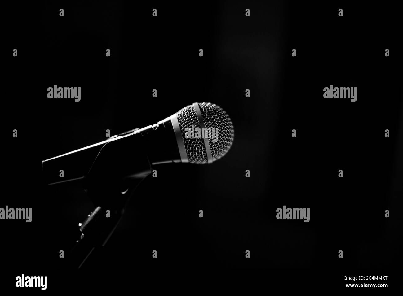 The microphone for the stage stands on a stand on a black background ...