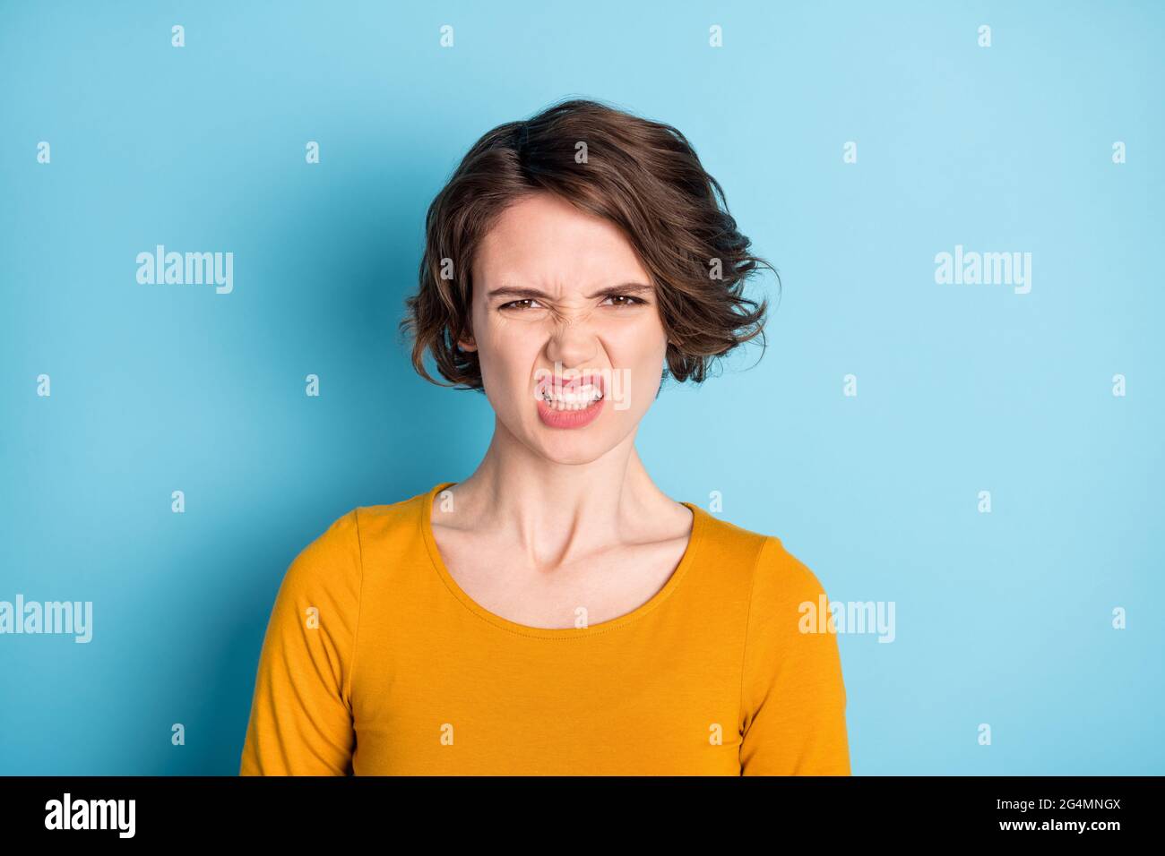 Photo of angry brunette lady show teeth wear yellow shirt isolated in vivid blue color background Stock Photo