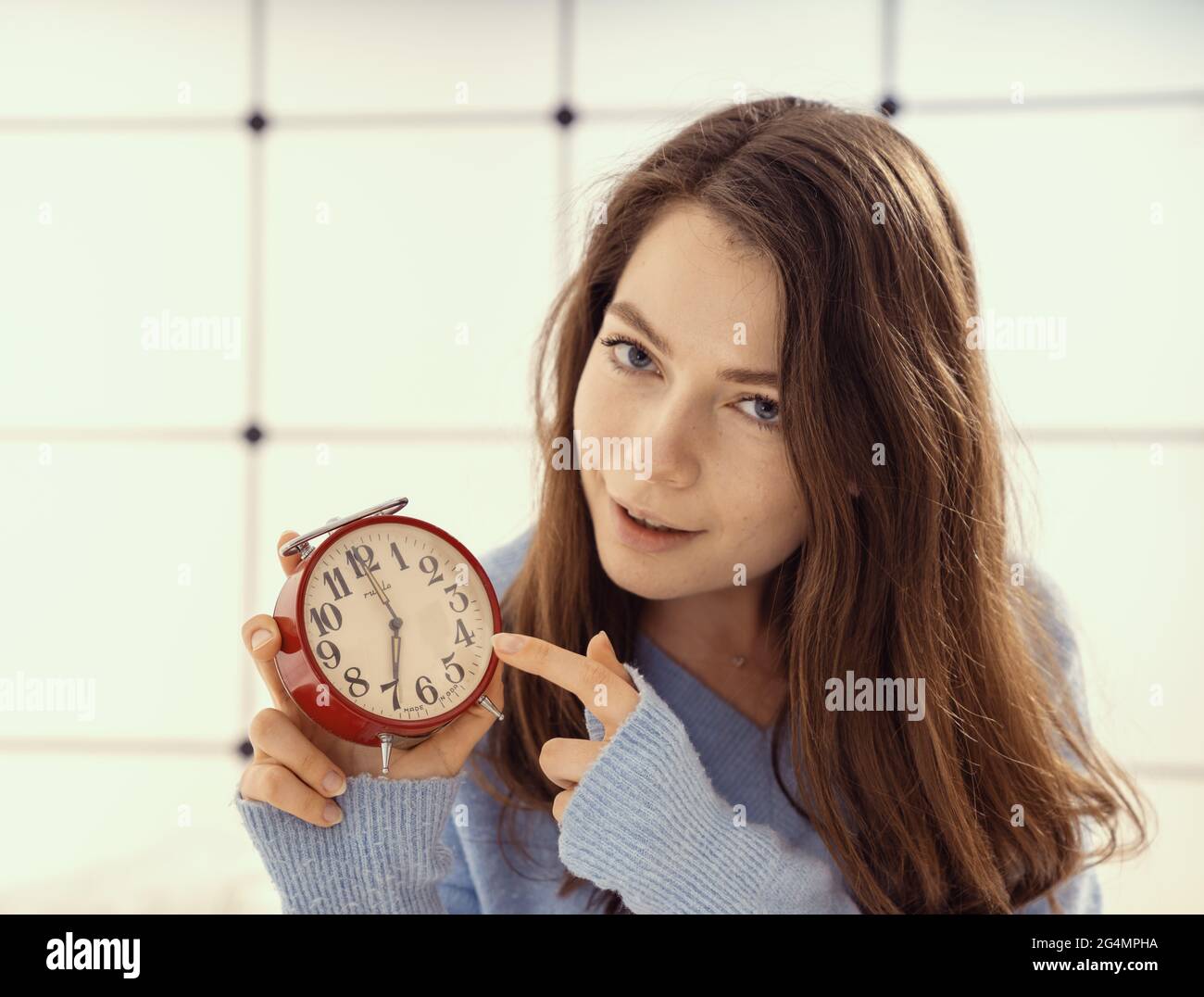 Ladies Time Sign Beautiful young woman showing time on alarm clock Stock Photo - Alamy