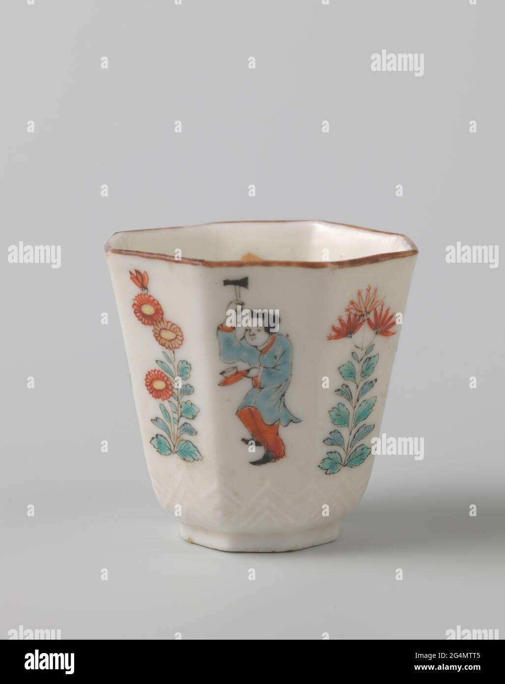 Octagonal Cup With Dancing Boys And Flowering Plants. Octagonal head of porcelain, covered with a translucent glaze and painted on the glaze in blue, red, green, yellow, black and gold. Above the foot a tire with modeled, pointed leaf motifs. Painted in Europe with alternating a dancing boy with an instrument and flowering plants. A floral drink on the bottom. Marked on the underside with an unidentified seal brand. Bak sand at the foot ring. Brown edge. Blanc de Chine in Europe decorated in the Japanese Kakiemon style. Stock Photo