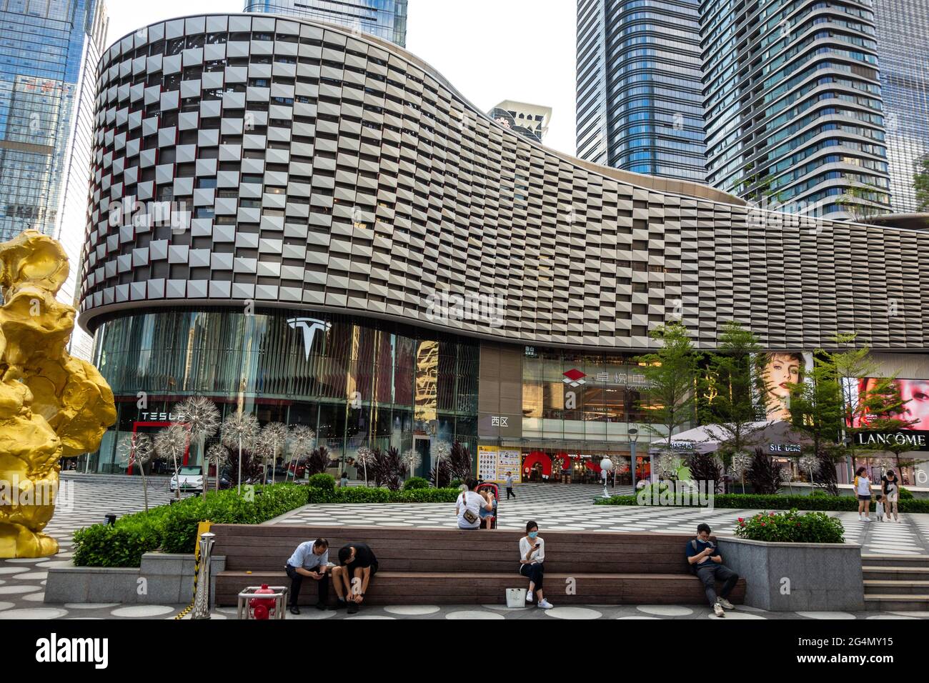 Exterior of modern shopping mall with people sitting in front in Shenzhen, China Stock Photo
