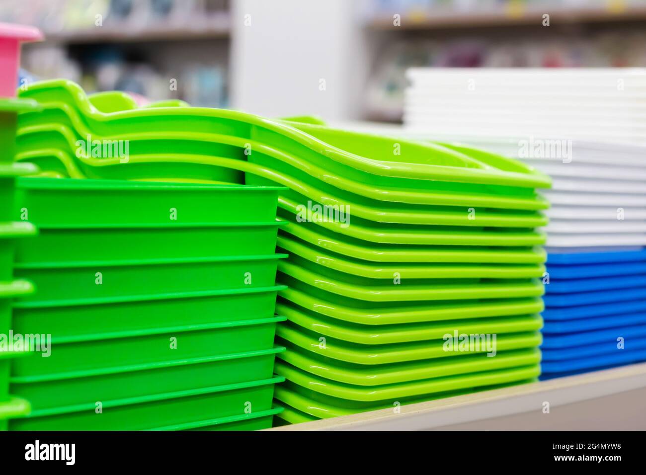 Photo of new packed multi colored plastic containers stacked on store shelf. Stock Photo