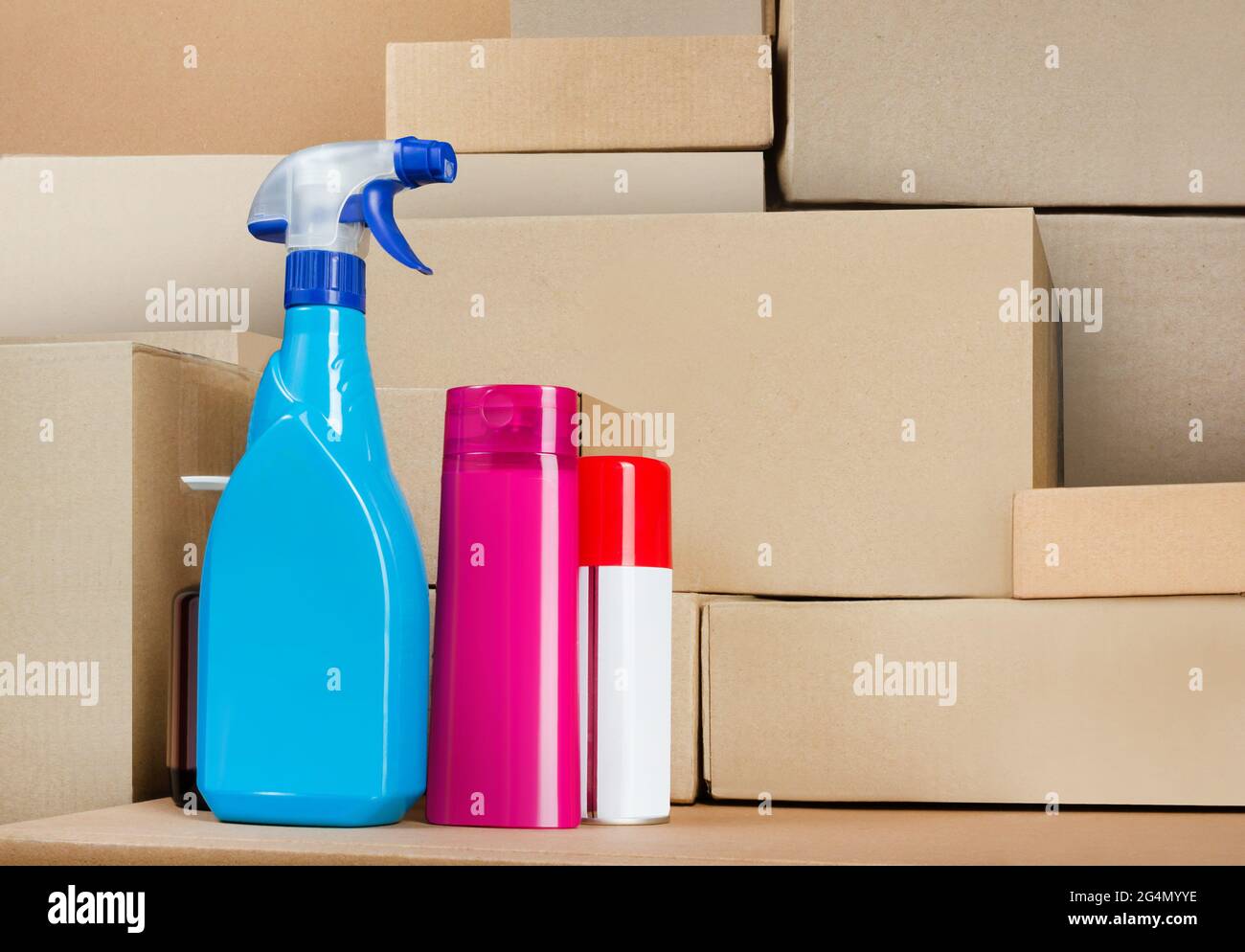 Photo of cleaning products standing on stacked cardboard boxes