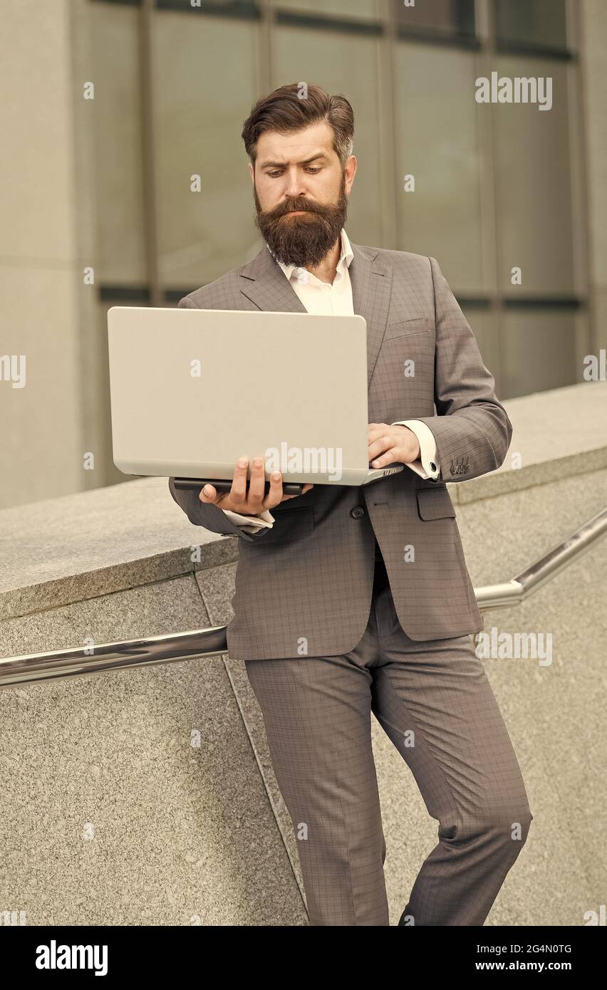 Computer communication network. Bearded man use computer outdoors. Business communication. Making video call. E-mail mail and messaging. Internet Stock Photo