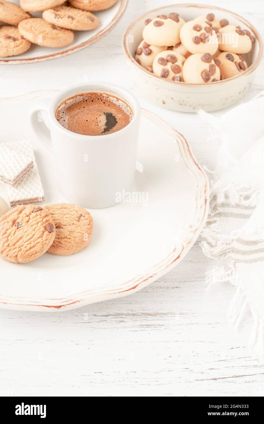 cup of coffee served with variety of cookie and biscuits on table Stock Photo