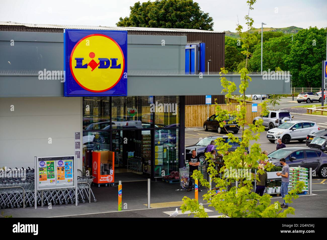 Lidl super market entrance and signage people parking cars in car park Wales UK Stock Photo