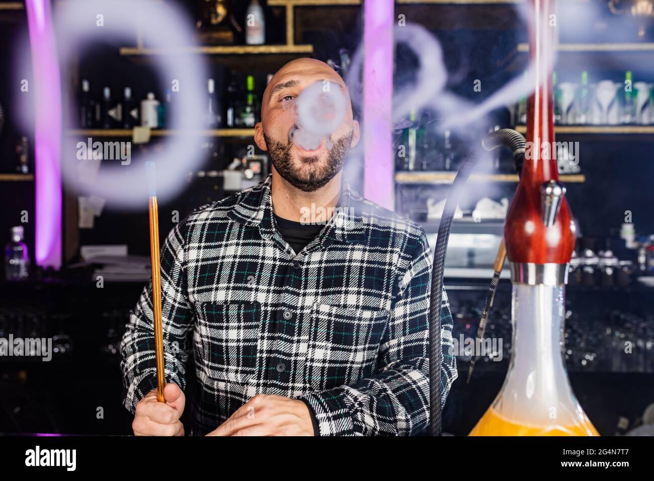 man smoking traditional hookah in a night club Stock Photo Alamy