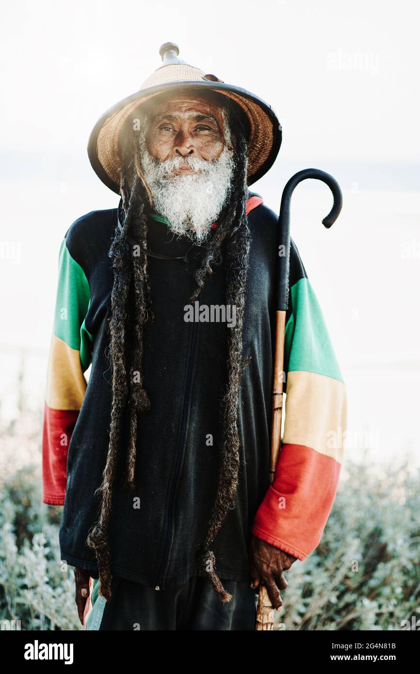 Portrait of old rastafari with dreadlocks looking at the camera in the nature with white background Stock Photo