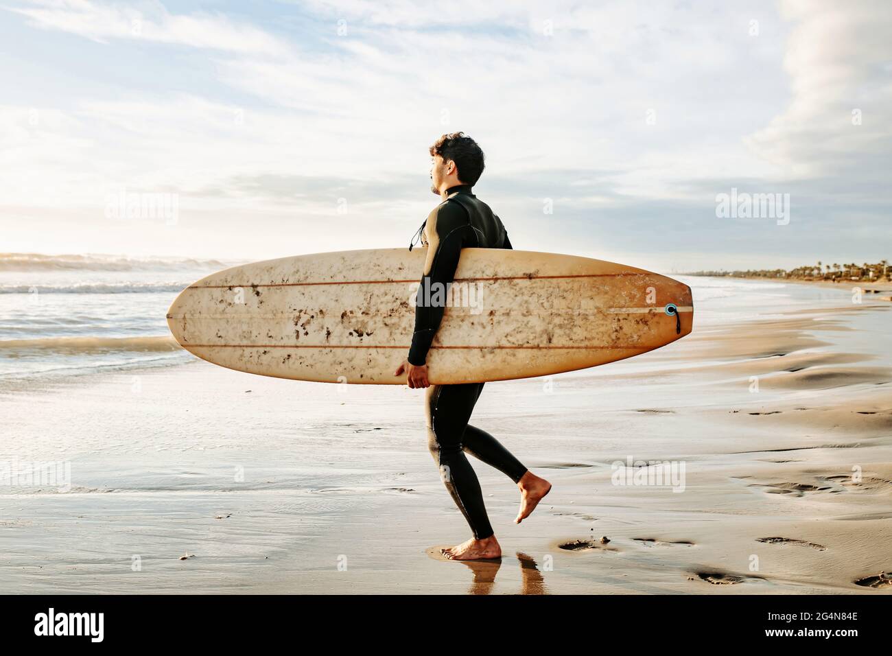 https://c8.alamy.com/comp/2G4N84E/side-view-of-surfer-man-dressed-in-wetsuit-walking-with-surfboard-towards-the-water-to-catch-a-wave-on-the-beach-during-sunrise-2G4N84E.jpg