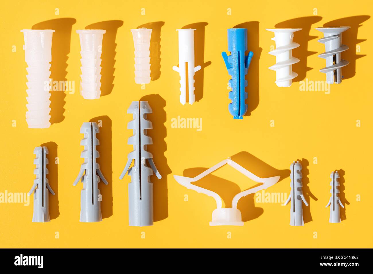 Top view of plastic dowels of different sizes with holes on ribbed surface in row Stock Photo