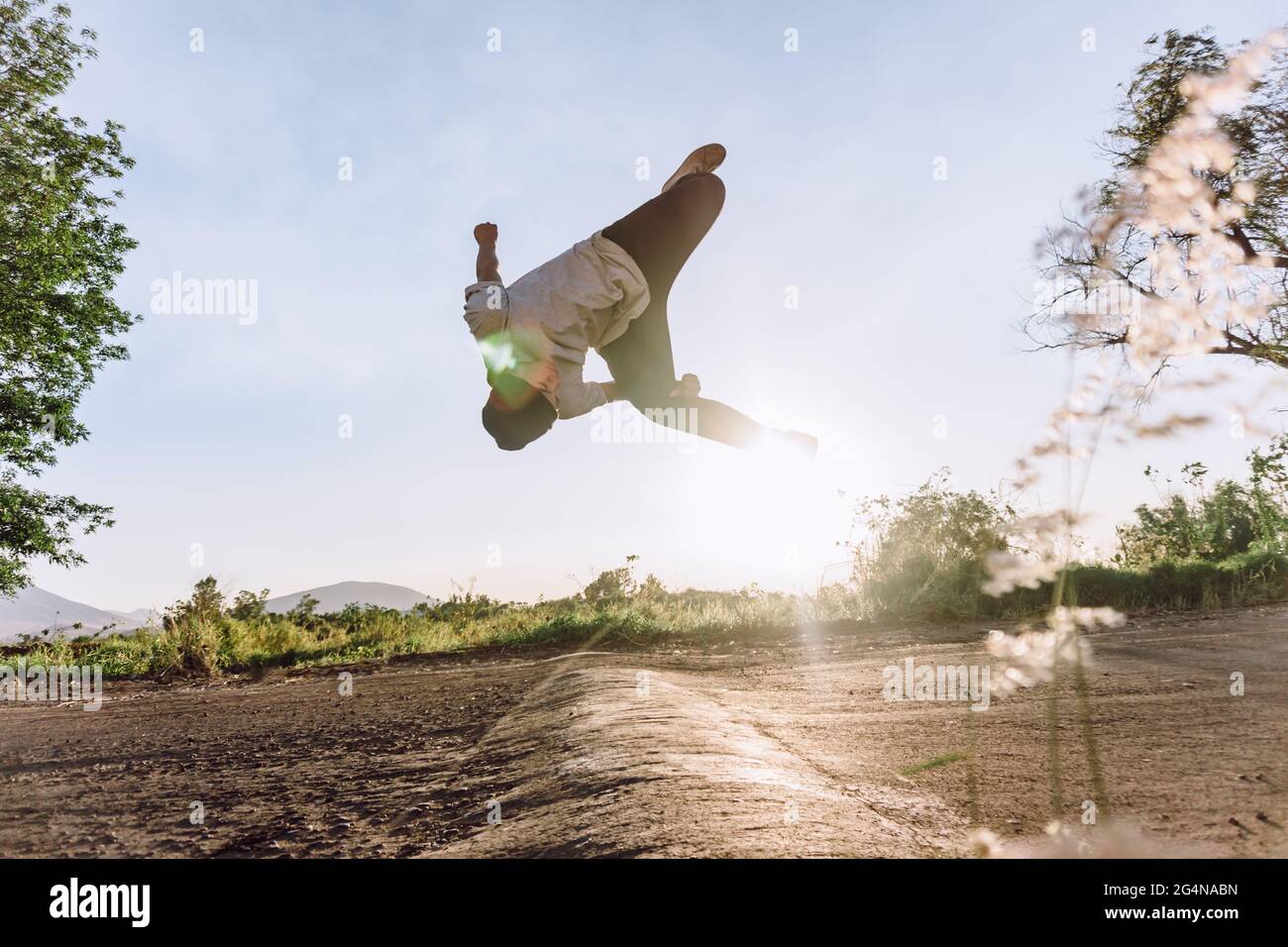 Acrobatic male jumping above ground and performing dangerous parkour trick  on sunny day Stock Photo - Alamy