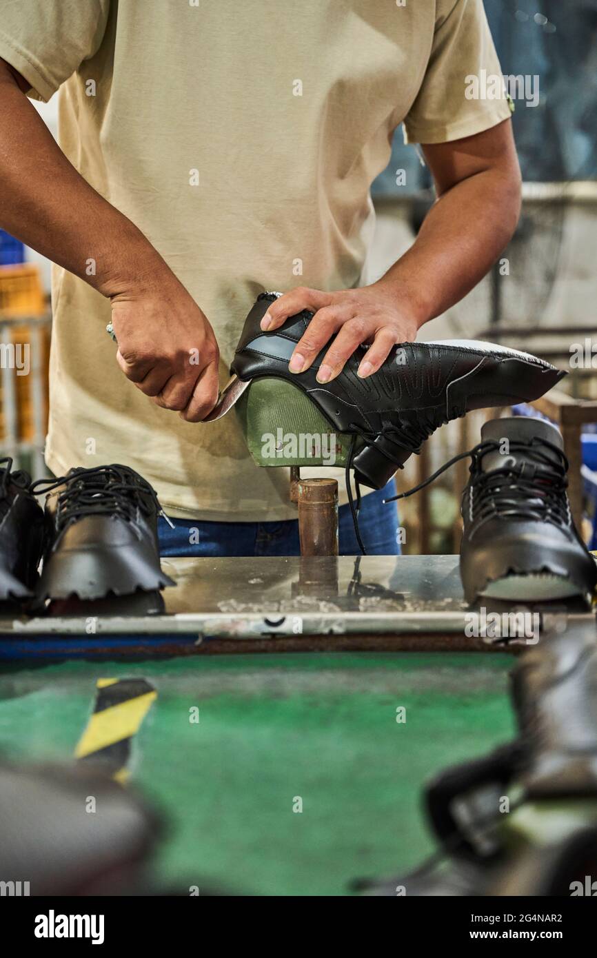 Detail of worker removing the mold from the shoes Chinese shoes factory Stock Photo