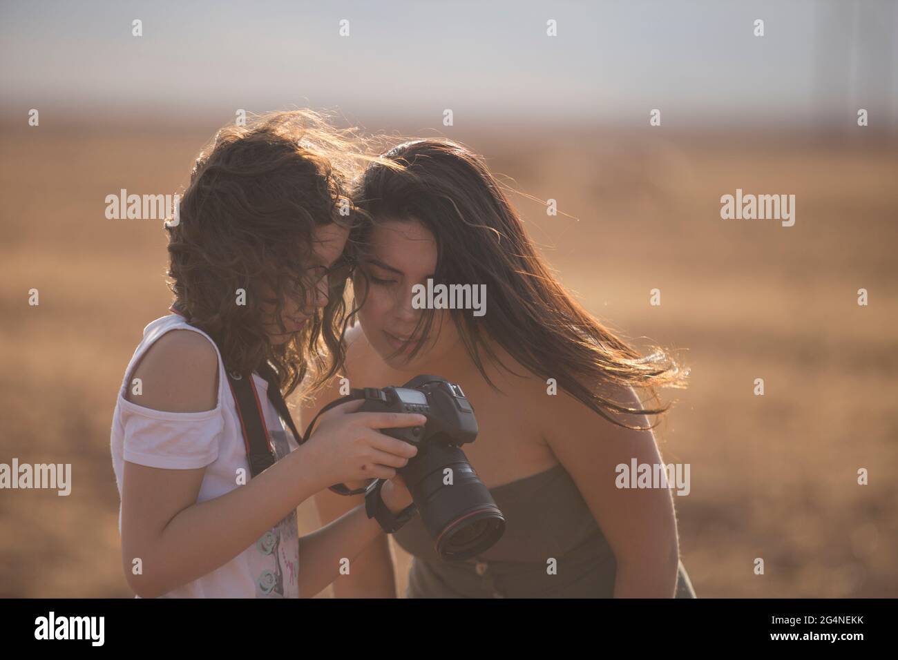 two women friends watching the display of a dslr camera Stock Photo