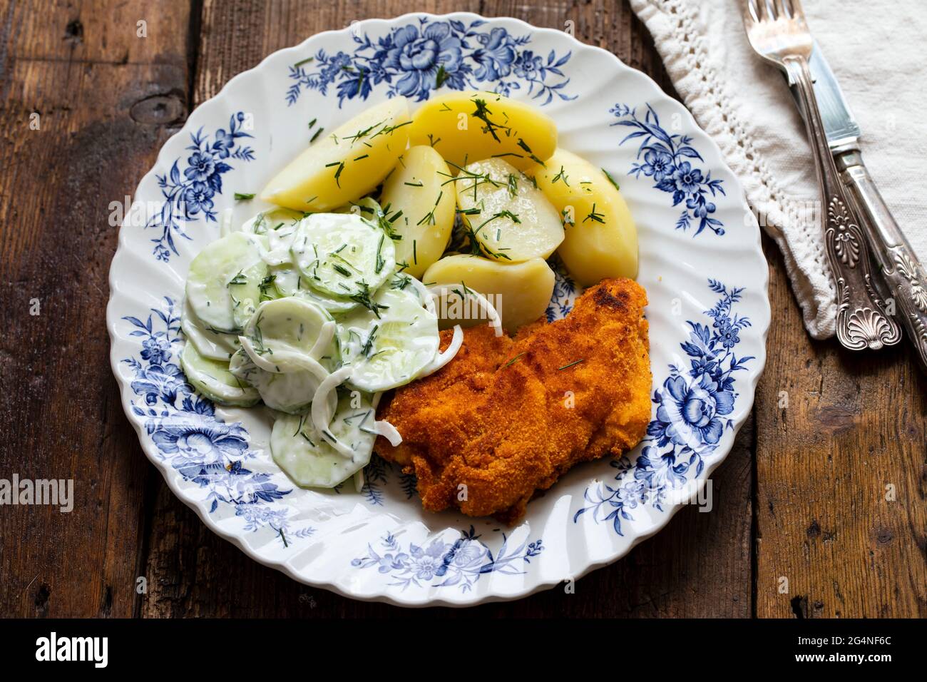 Chicken escalope, baby potatoes and cumcumber and onion salad Stock Photo