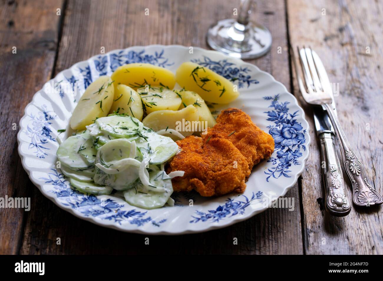 Chicken escalope, baby potatoes and cumcumber and onion salad Stock Photo