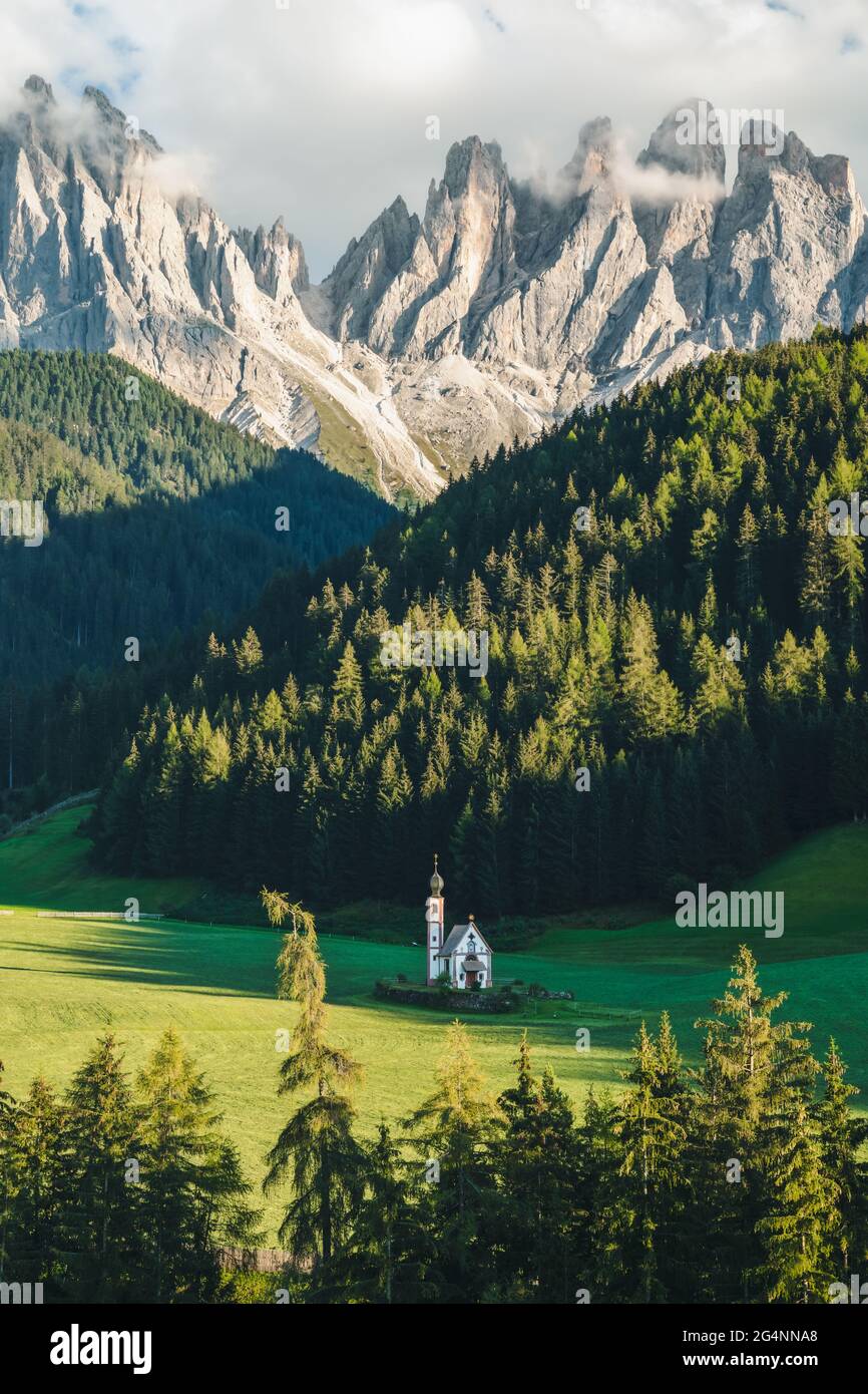 St Magdalena church in Val di Funes valley, Dolomites, Italy. Furchetta and Sass Rigais mountain peaks in background Stock Photo