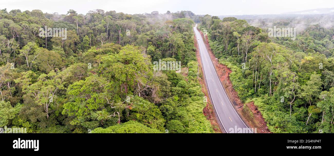 Aerial shot of an Amazonian highway in Ecuador Roads bring colonization and destruction of the rainforest to the Amazon Basin. Stock Photo