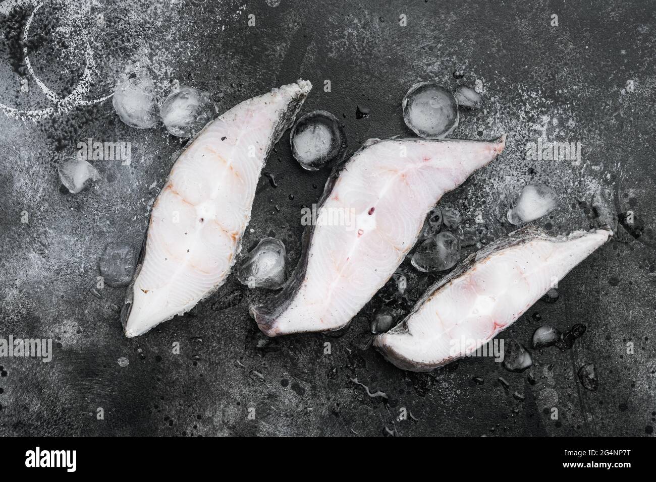 Frozen fish steak set, on black dark stone table background, top view ...
