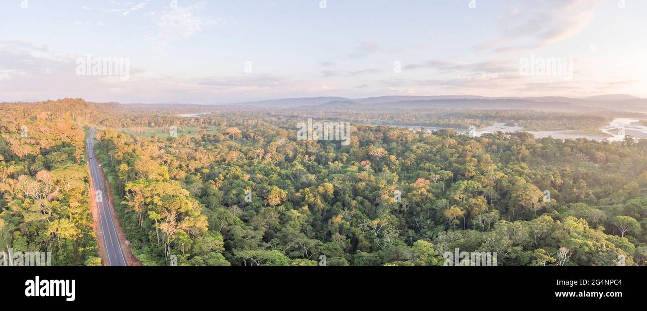 Aerial panorama of an Amazonian highway in Ecuador with Rio Napo in the background.  Roads bring colonization and destruction of the rainforest to the Stock Photo