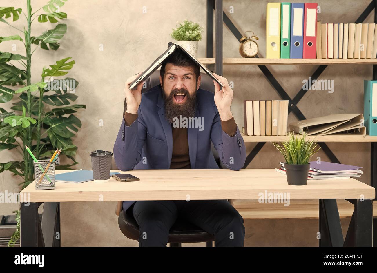 In his own crazy way. Crazy man hold laptop on head. Computer ...