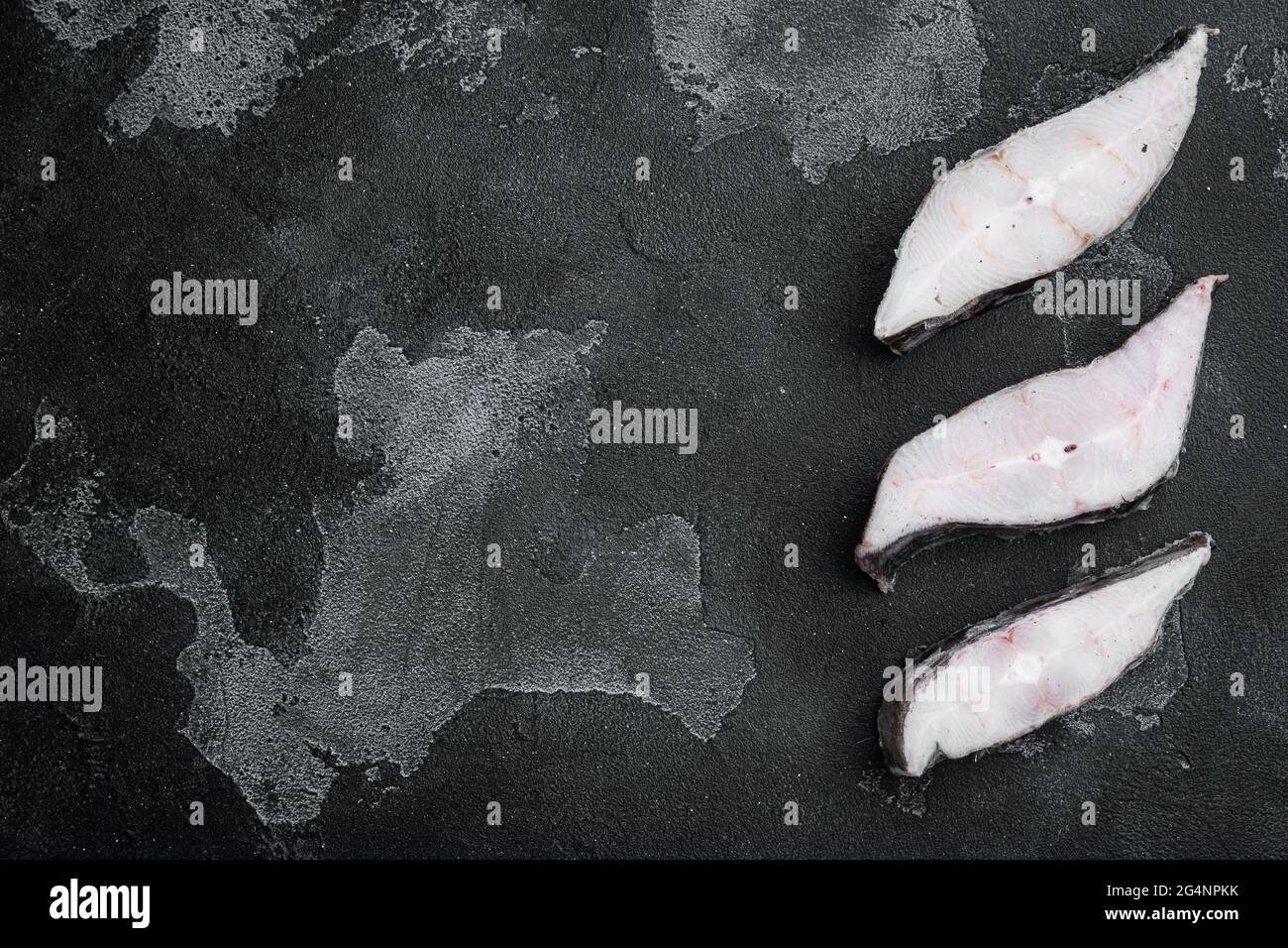 Steaks of fish and fillet of sea fish frozen set, on black dark stone ...