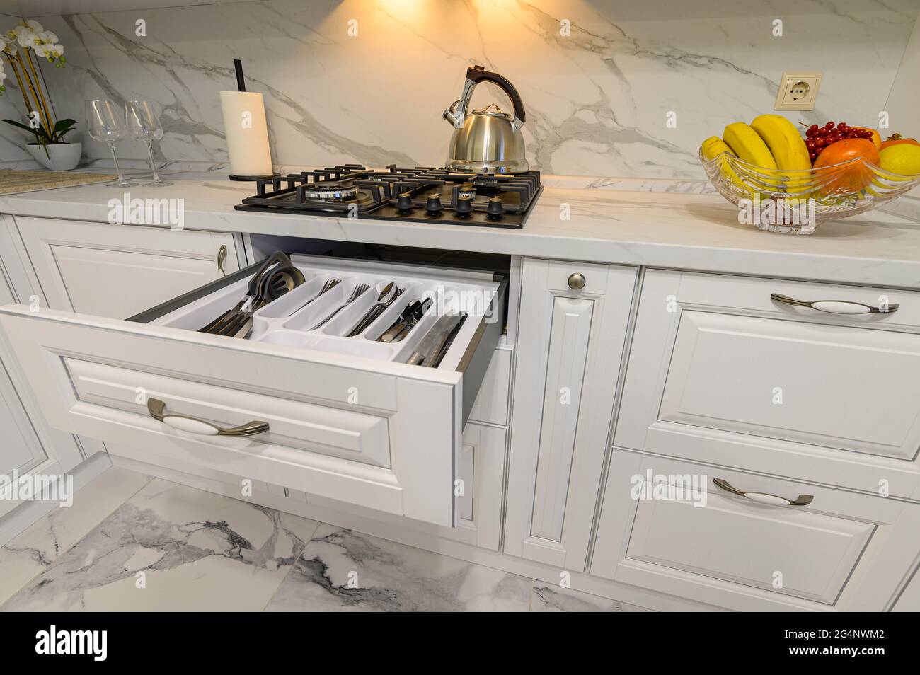 Open drawers with kitchenware at modern white kitchen Stock Photo - Alamy
