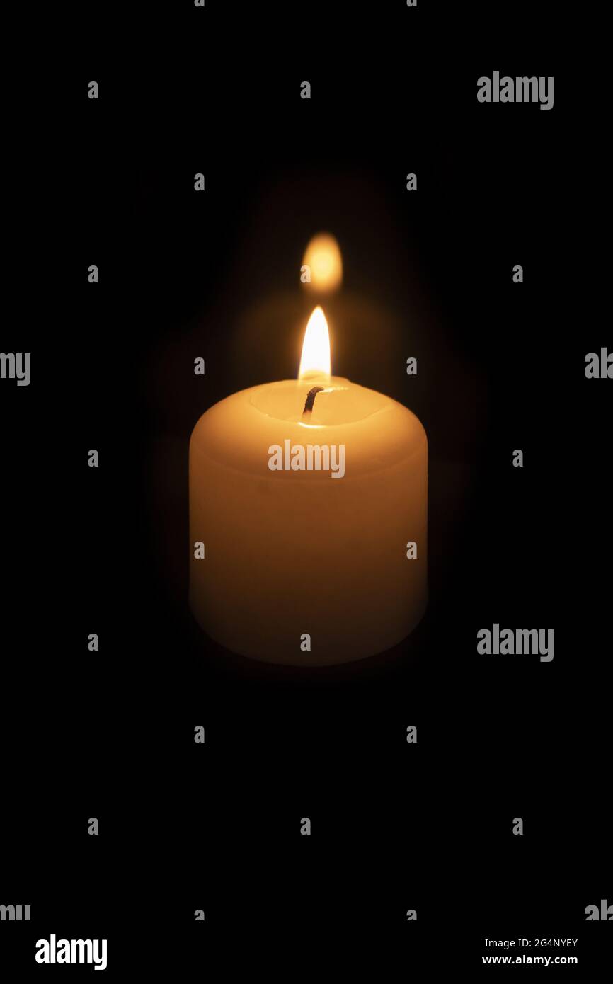 Light from a wax candle burning in the dark. Candle lighting. Candle