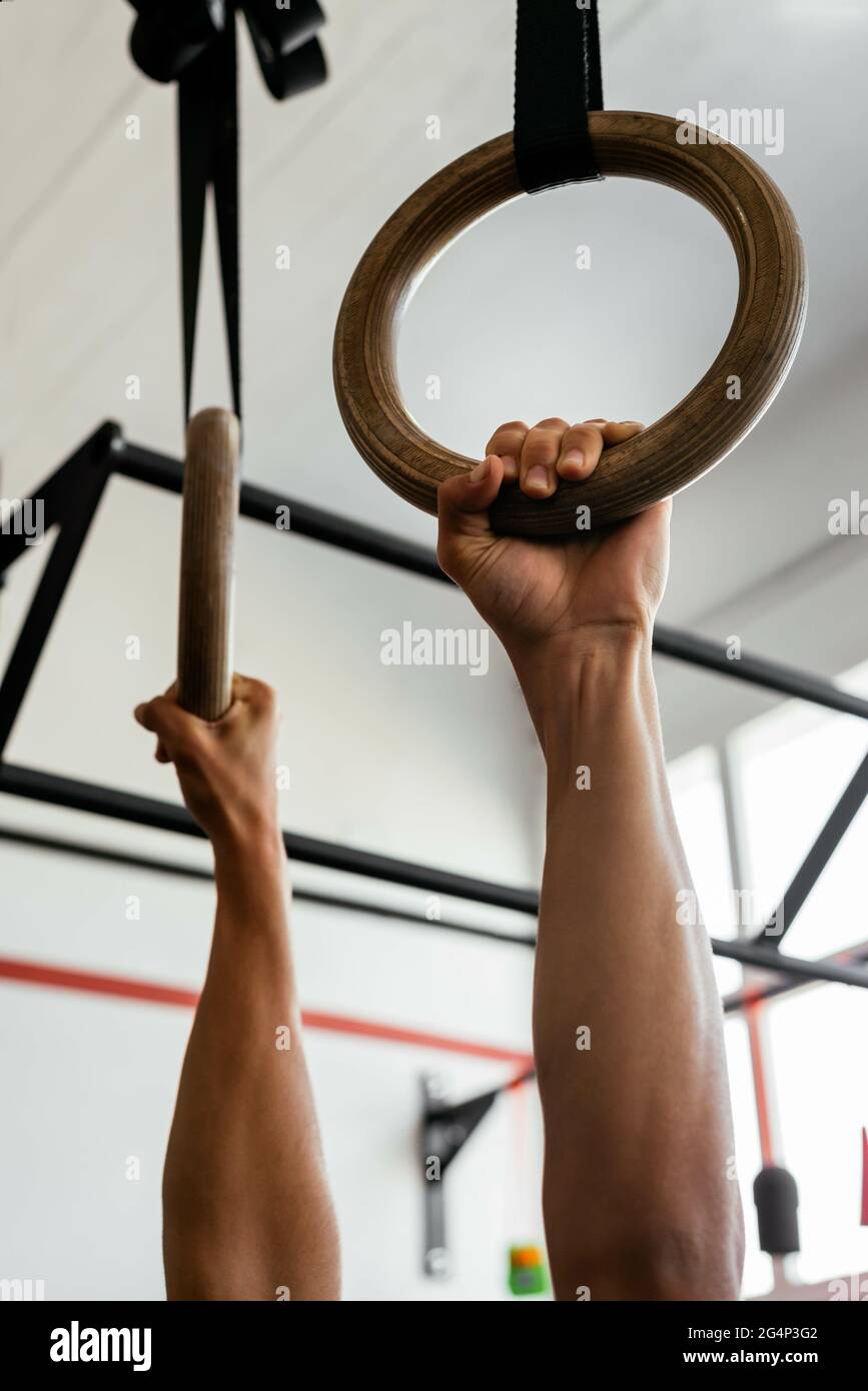 Sportsman Holding Rings exercising at a gym Stock Photo - Alamy
