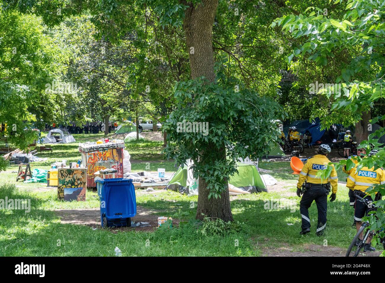 Toronto police and security forces clear out a homeless people encampment in Trinity Bellwoods Park, Canada. Stock Photo