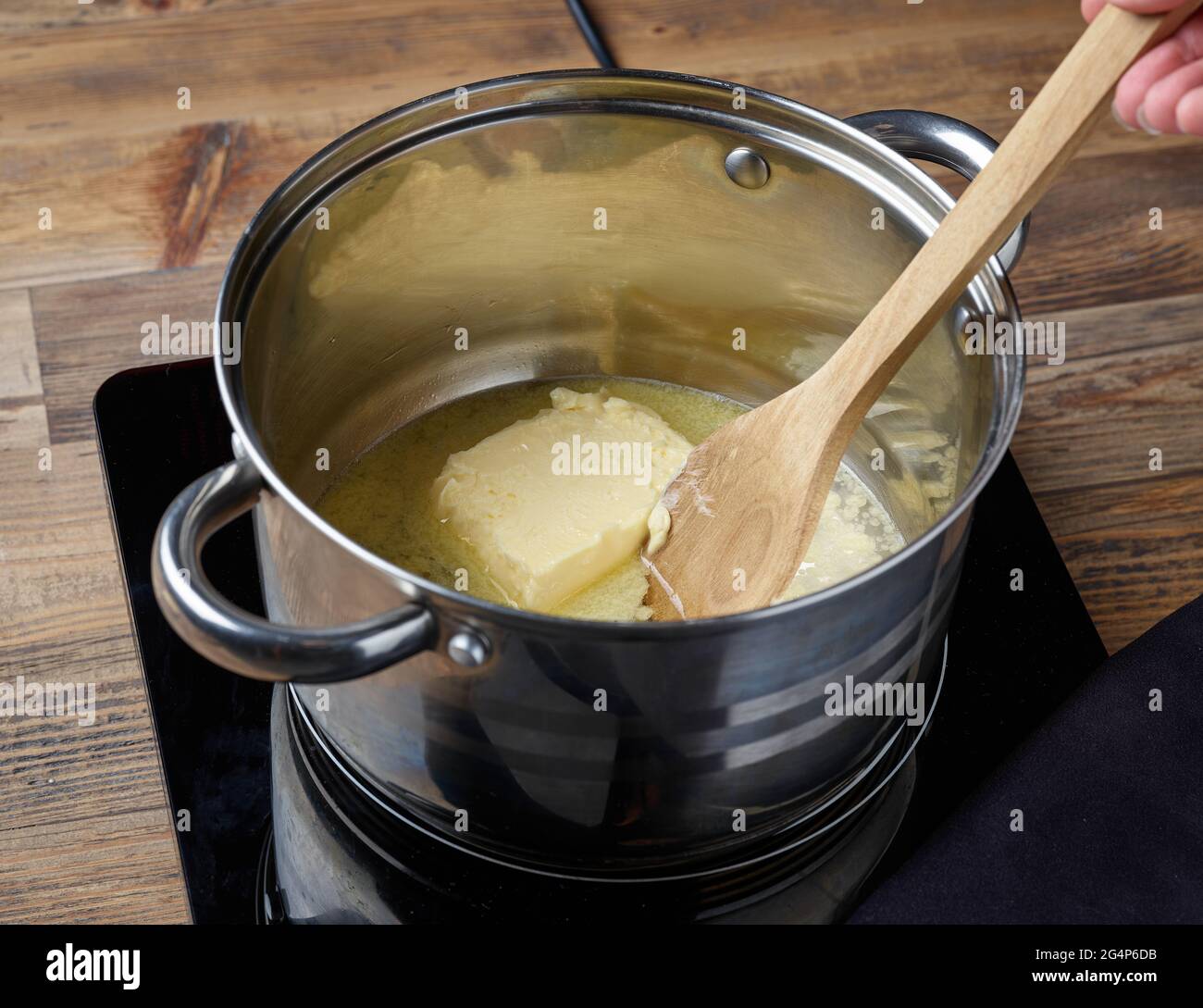 water, salt and butter in a pot for making eclair dough Stock Photo