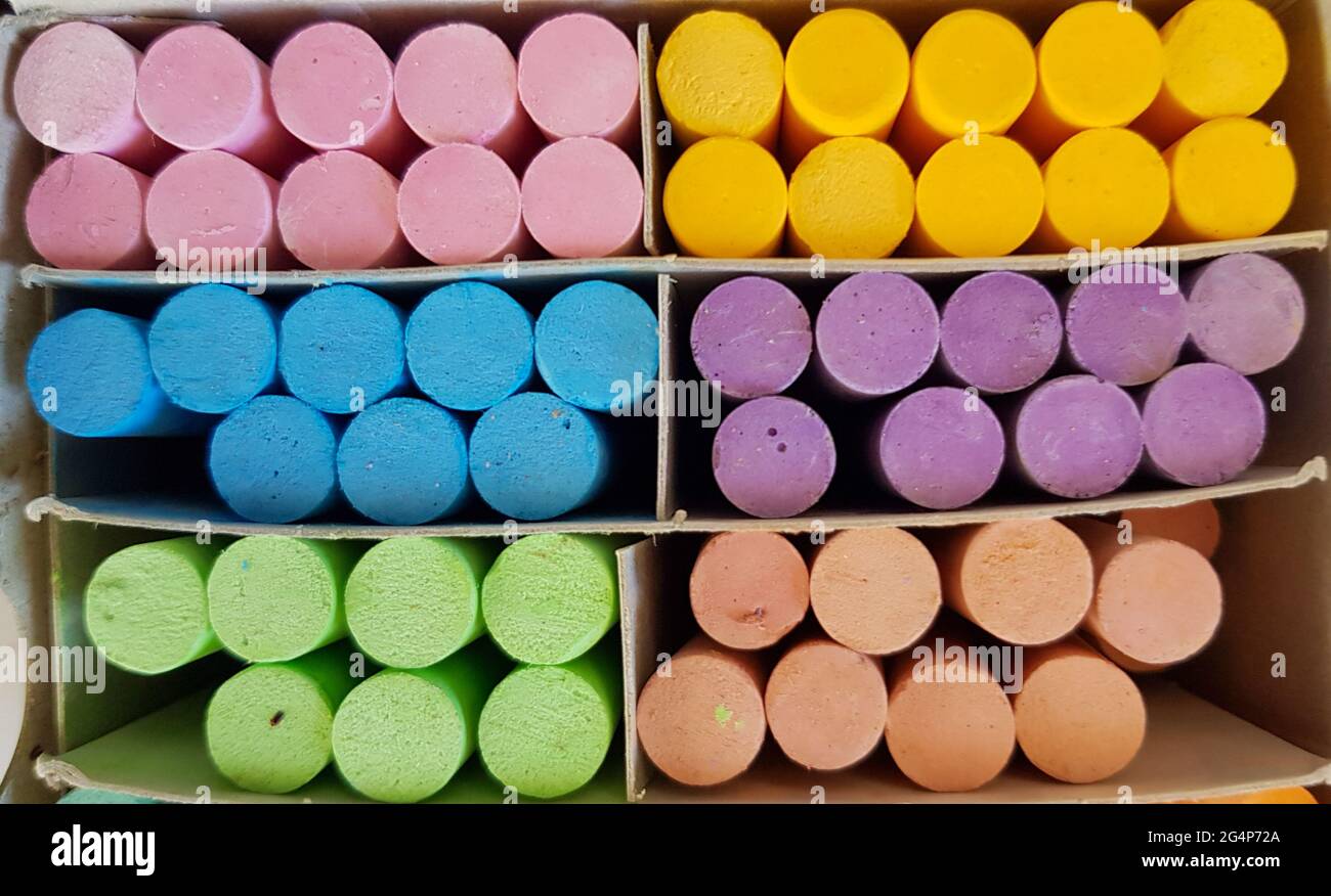 Different colored chalks are neatly arranged in a box. Stock Photo